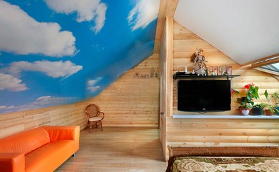 Натяжной потолок с фотопечатью в деревянном доме. Потолок повторяет наклон крышы