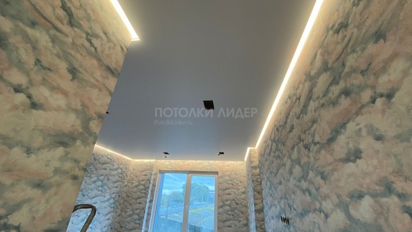 Полотно натяжного потолка  установлено, в нём сделаны вырезы под прямоугольные светильники