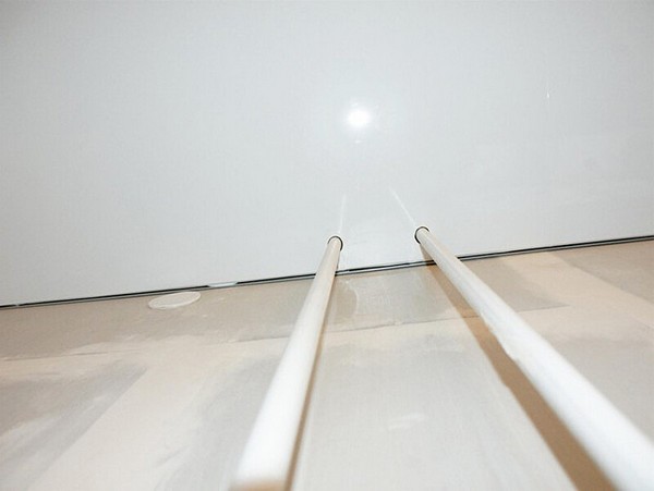 На фото: две трубы отопления, которые обошли натяжным потолком, но обводы наклеили не на лицевой стороне потолка, а на обратной